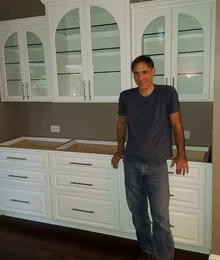 Stewart True beside custom white cabinetry, about 15 years ago